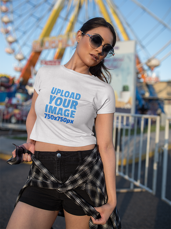 white woman wearing a crop top t shirt mockup at an amusement park